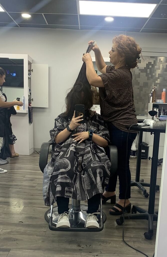A stylist working on a client in the Burbank Hair Studio chair